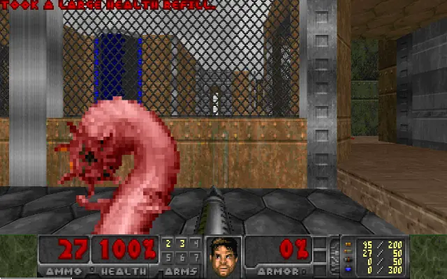 Freedoom Phase 1: a worm creature attacks in front of a mesh fence