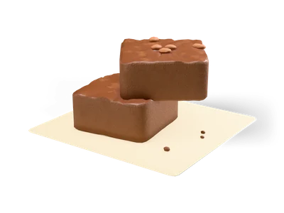 Two chocolate brownies with crackled tops and walnut pieces stacked on baking paper
