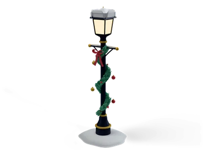 Black street lamp with glowing lantern and snow cap, wrapped in a green fir garland with red bow and baubles